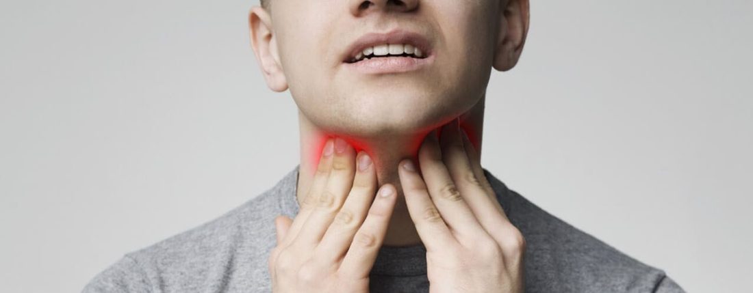 A man touching his neck, indicating a sore throat