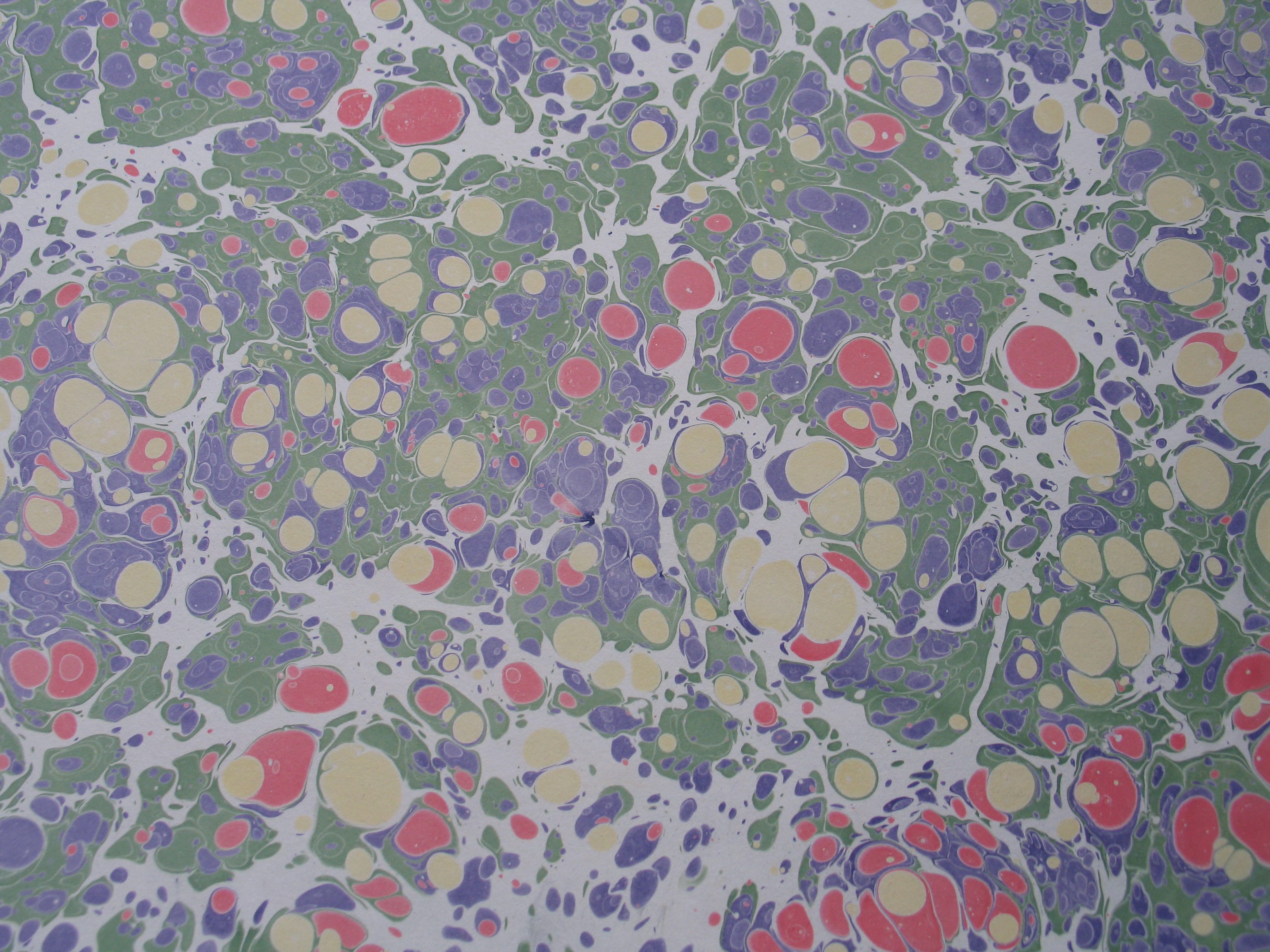 A rectangular, linen-bound journal in muted sage green, closed with a delicate ribbon, resting atop a stack of vintage letters and a porcelain teacup.