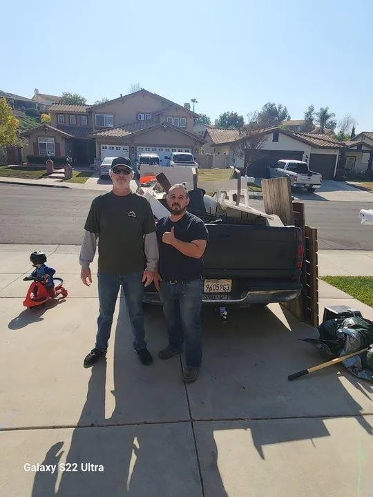 Commercial junk removal by Rabbits Services with a trash bin full of debris in Riverside, including furniture and household items
