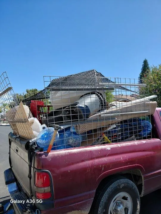 Rabbits Services loading large appliances and debris onto a truck for removal, providing fast cleanout services in Temecula
