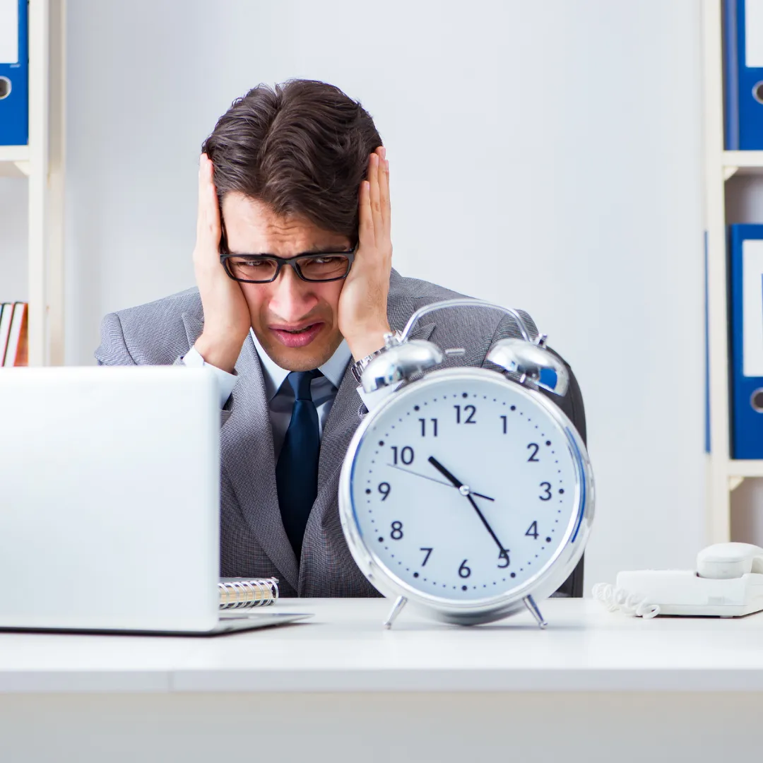 Stressed Person with Clock on desk