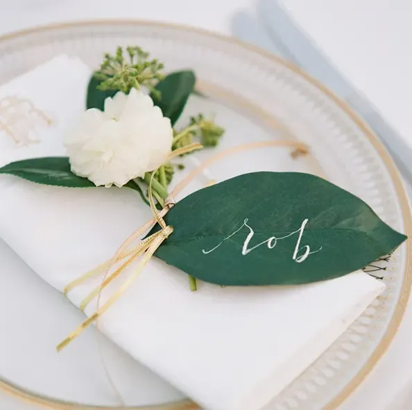 calligraphy escort cards on a green leaf