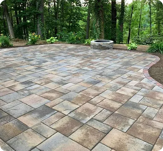 Paver patio with a circular fire pit in a residential backyard