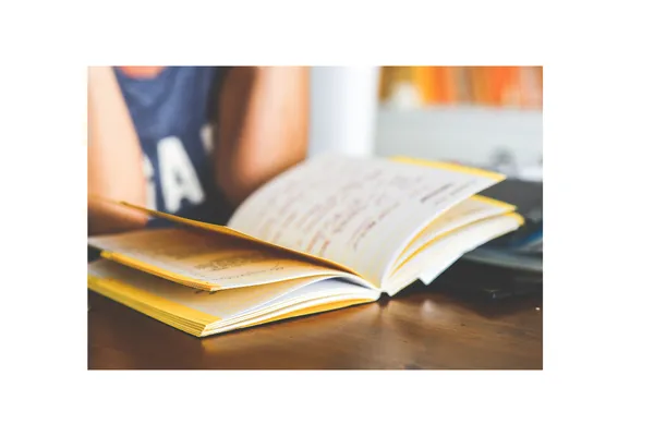 Students reading an open book on a desk