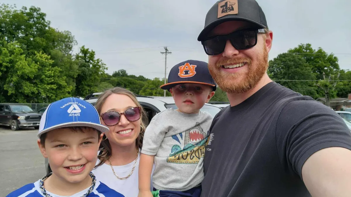 family of four standing in a parking lot