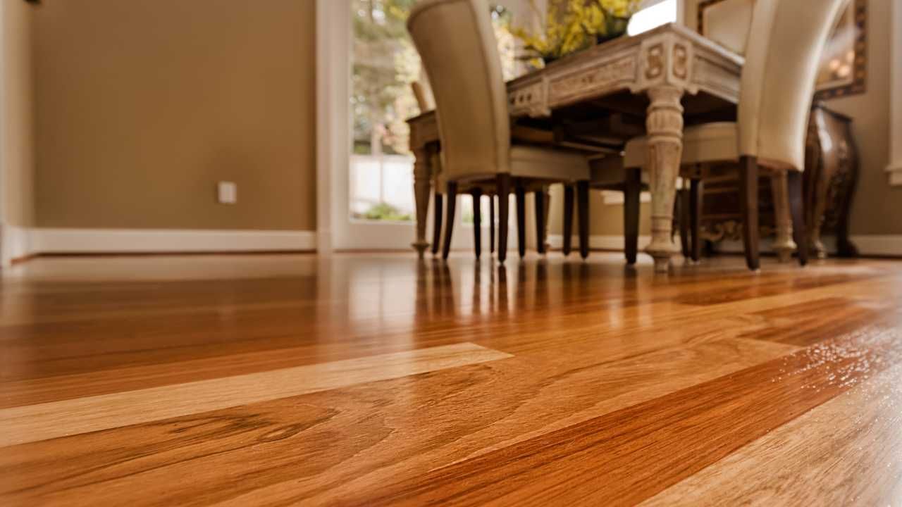 A wooden floor in a dining room with a table and chairs.