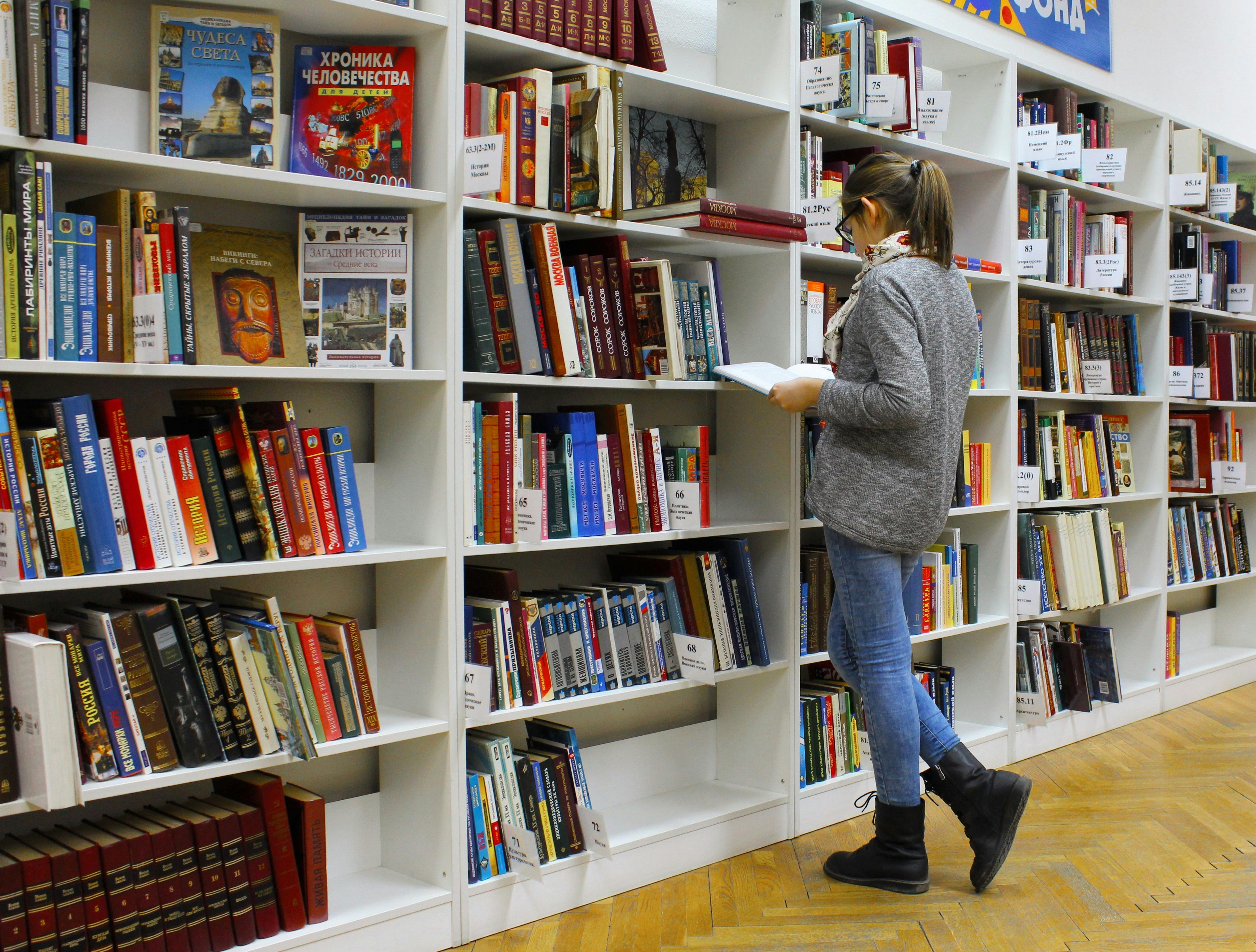 Student looking over books in the library