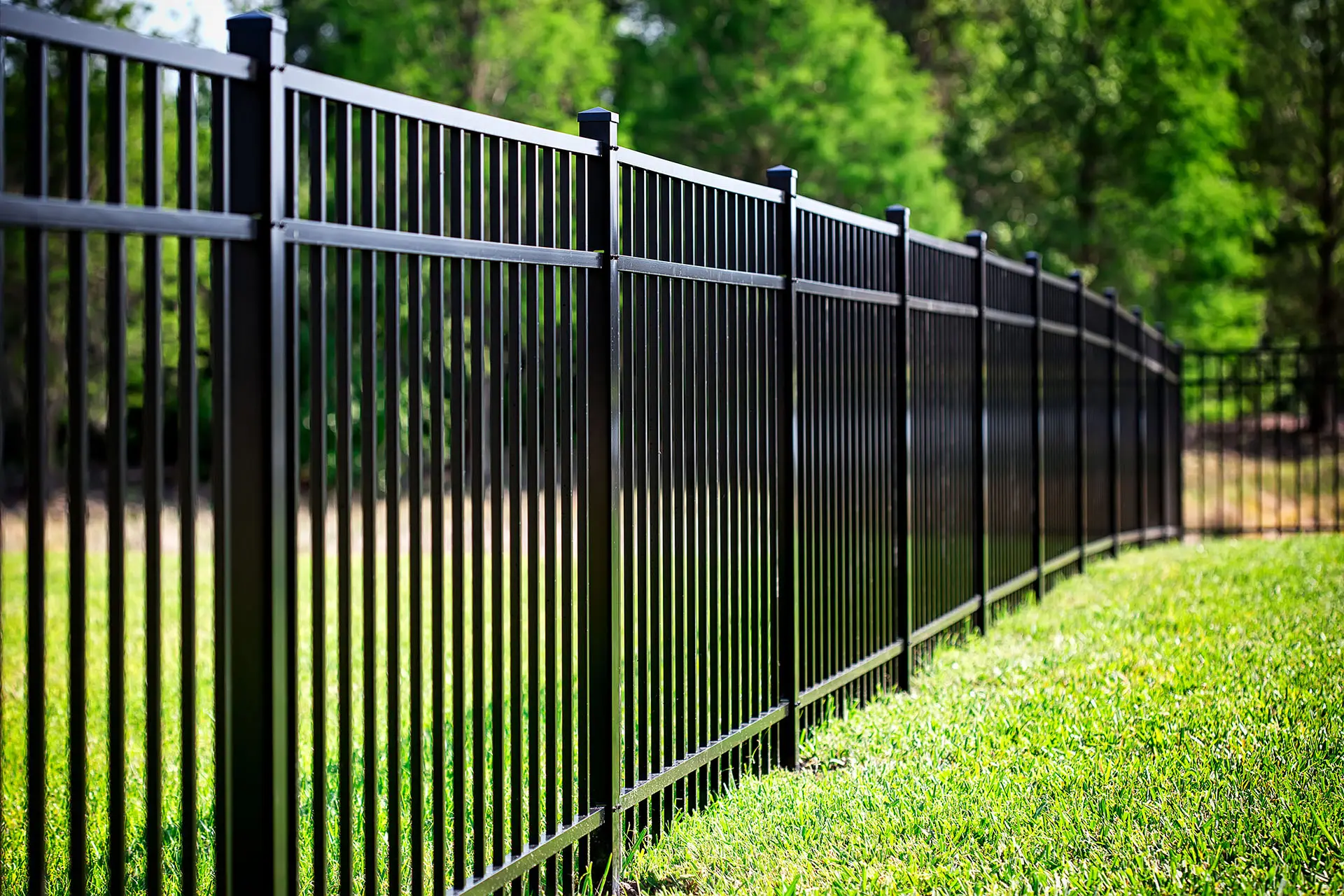 a black aluminum fence of a yard