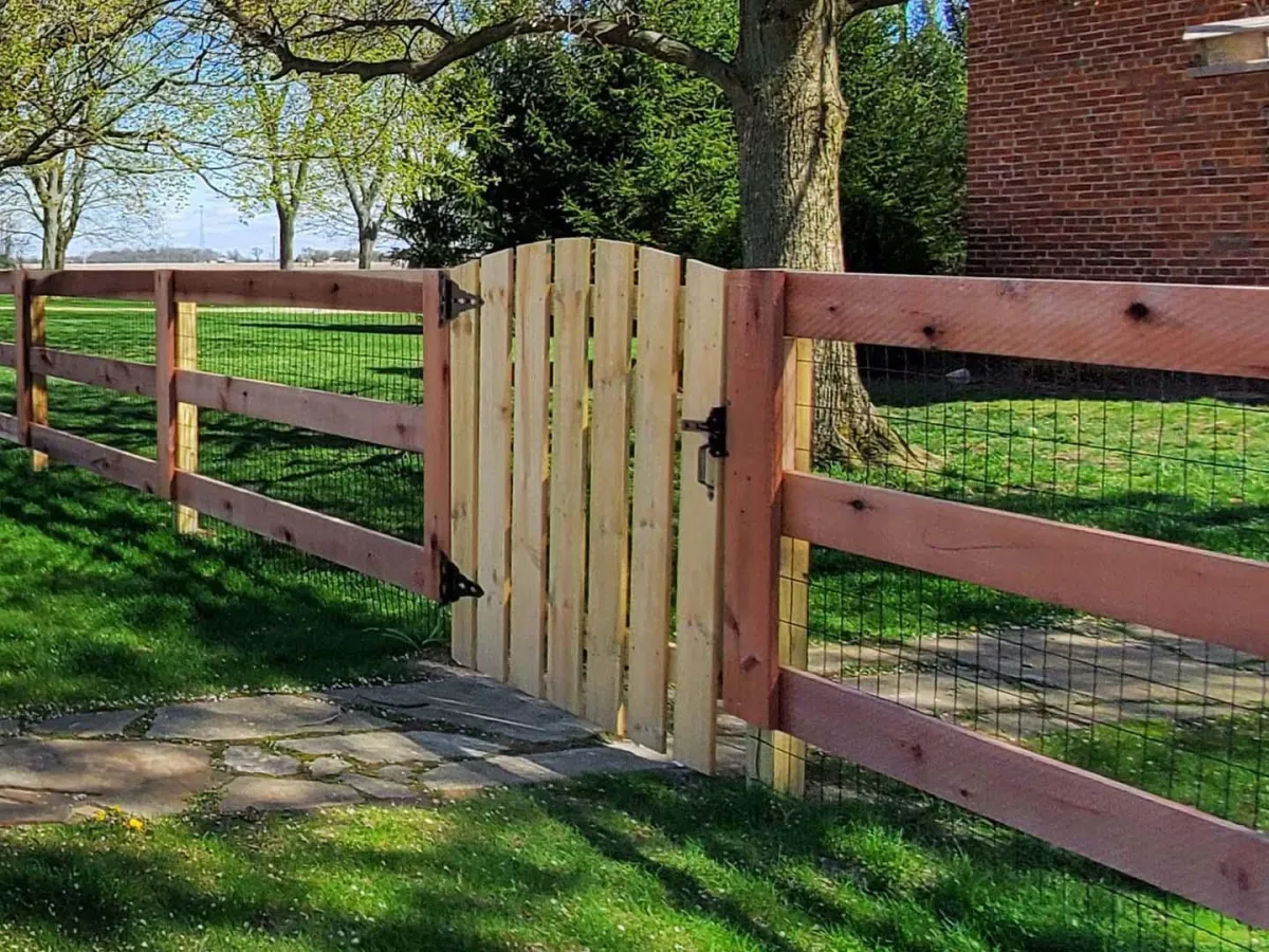 a wooden fence with metal screen