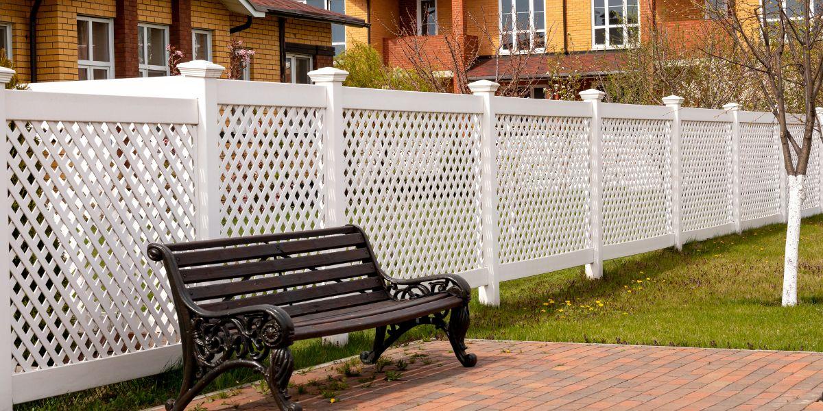 a white fence beside a black bench