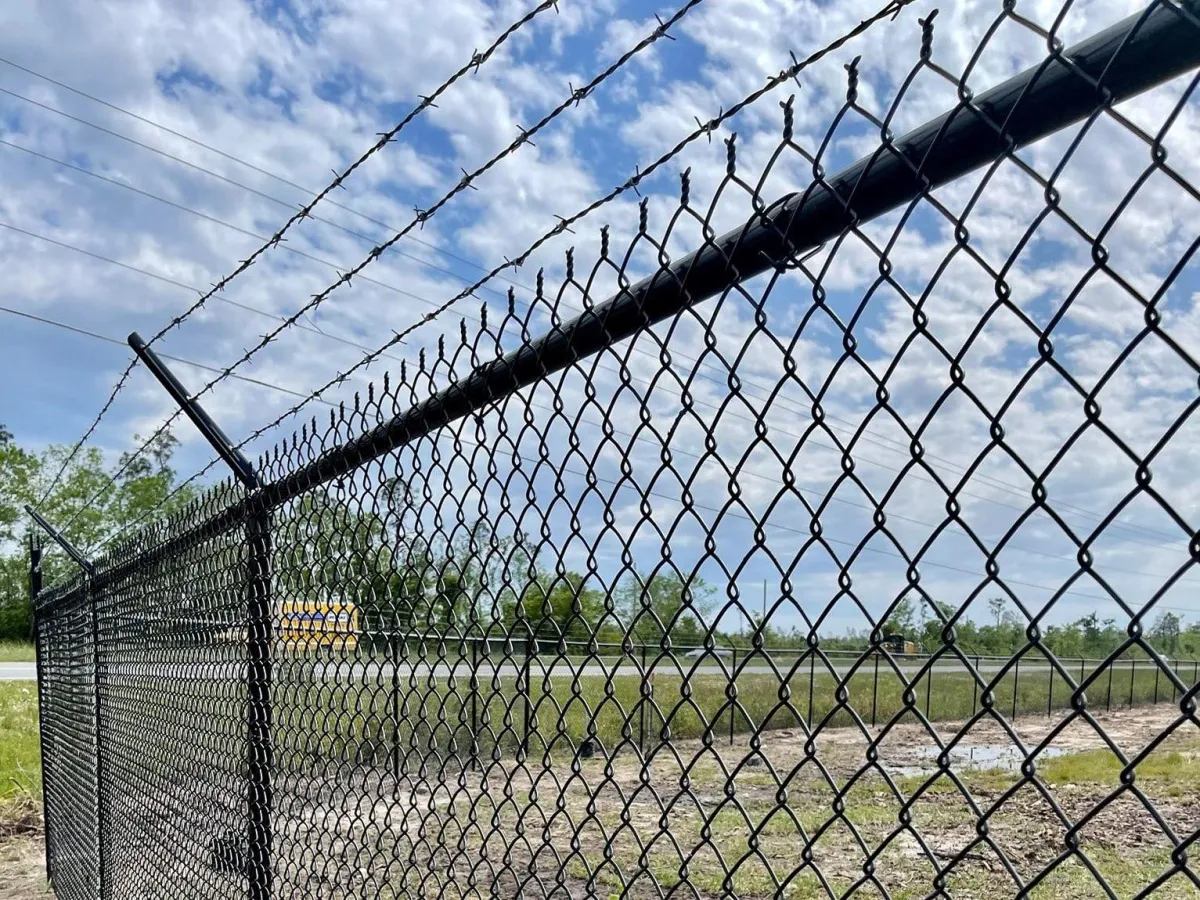 a chain linked fence with barbed wires