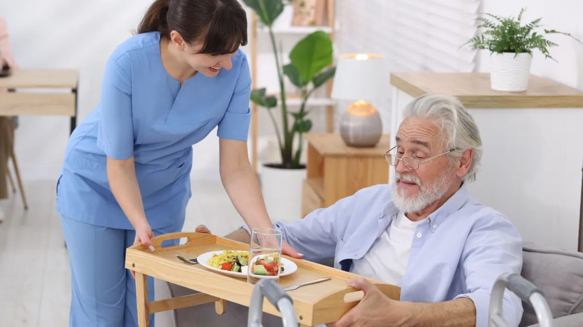 Home care services caregiver assisting senior with dementia during mealtime in Lakewood CA