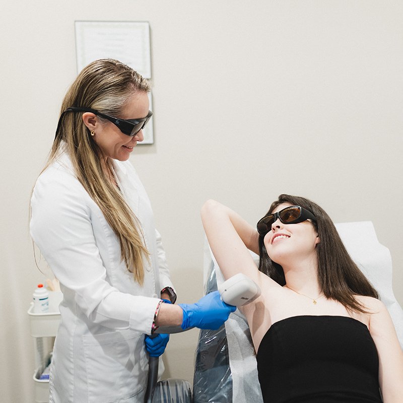 Tratamiento láser facial en un medical spa moderno: equipo profesional con gafas de protección en sala limpia y elegante