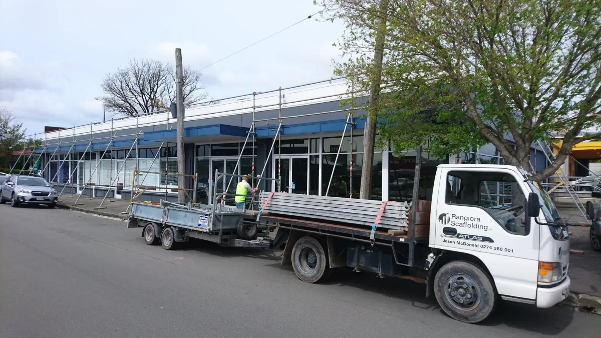 Rangiora Scaffolding truck and trailer parked at a commercial site with scaffold setup in progress along a shopfront in Canterbury