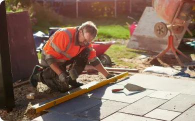 Skilled mason installing a custom stone paver patio for a durable outdoor living space