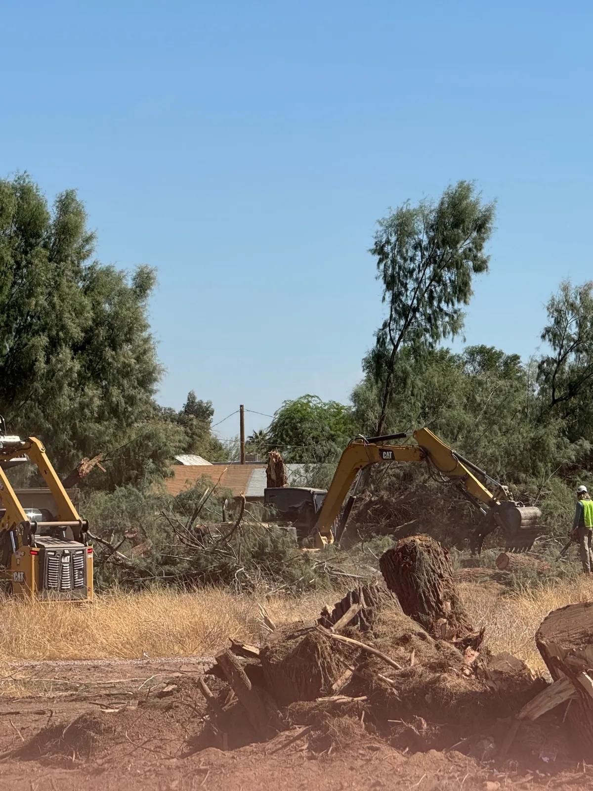 heavy operating equipment clearing a residential lot performing land clearing services