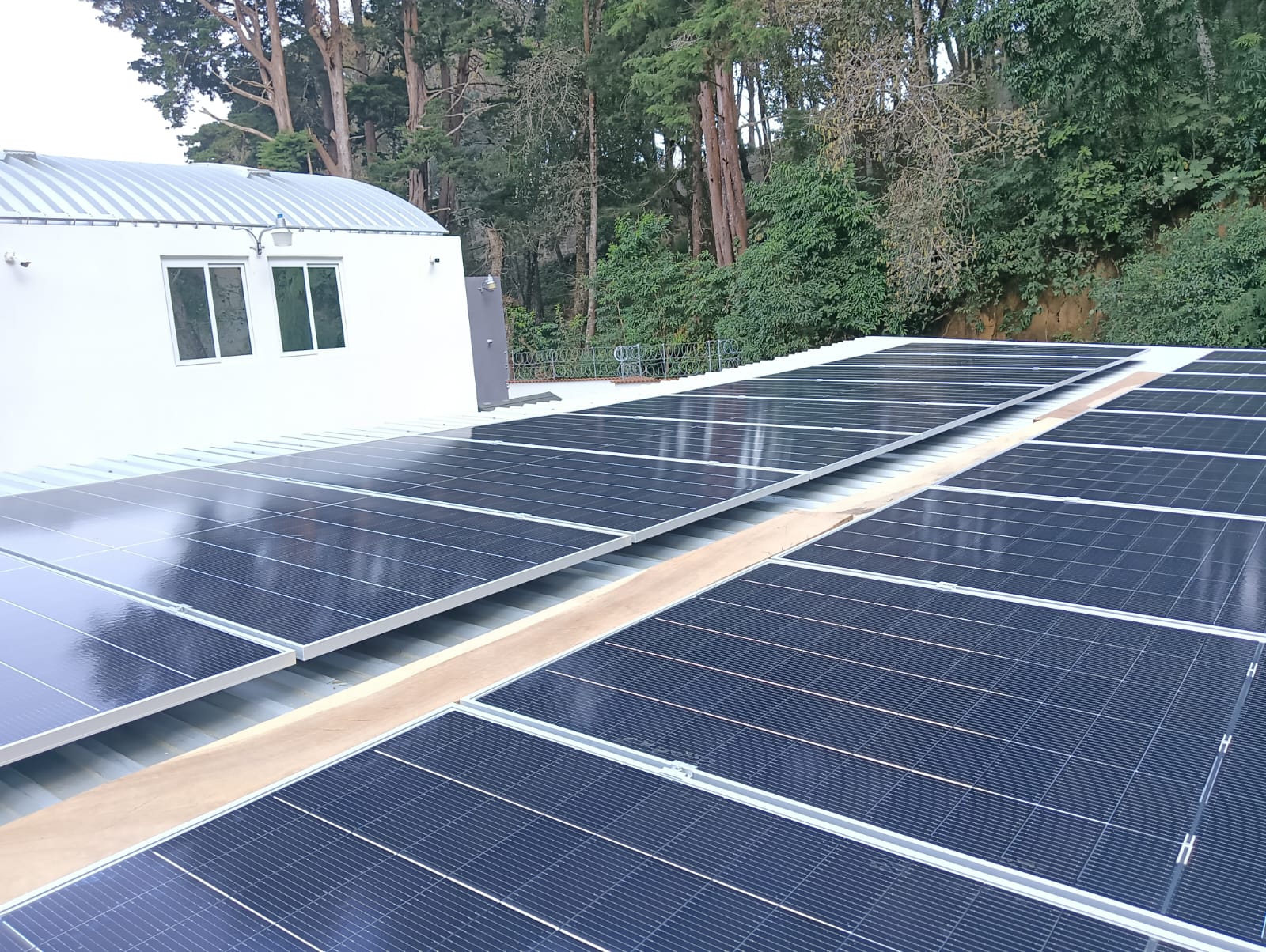 Instalación solar en vivienda de Posadas, Misiones, adultos mayores conversando en la galería, cielo despejado