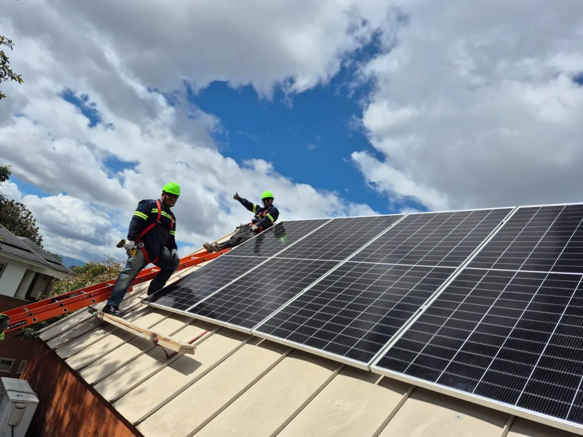 Instalación solar en vivienda de Posadas, Misiones, adultos mayores conversando en la galería, cielo despejado