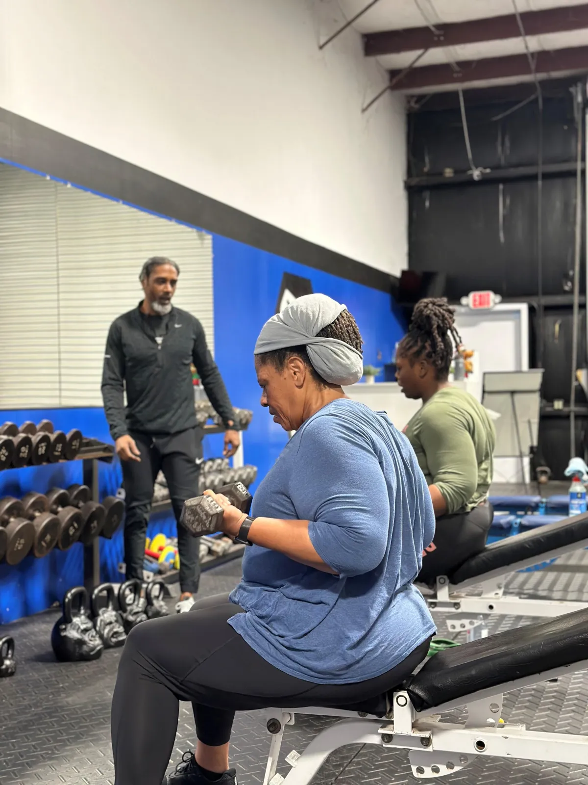 Personal trainer training two clients for a buddy training program