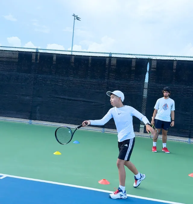 Niño entrenando desplazamiento lateral con conos en Zenniq Academy Katy TX, programa formativo de tenis con supervisión profesional