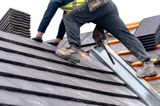Roofer laying tiles on a pitched roof