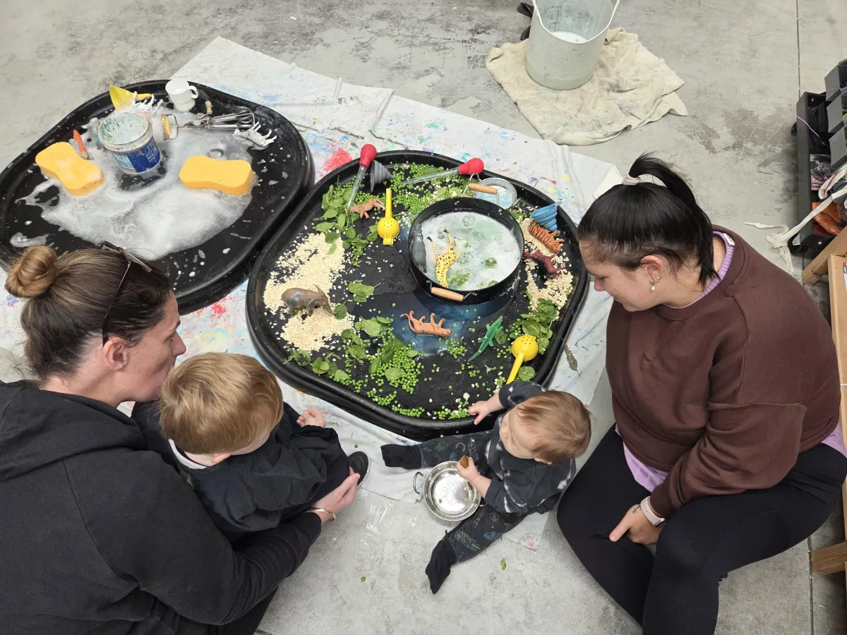 Portrait of a smiling mother holding a framed child collage