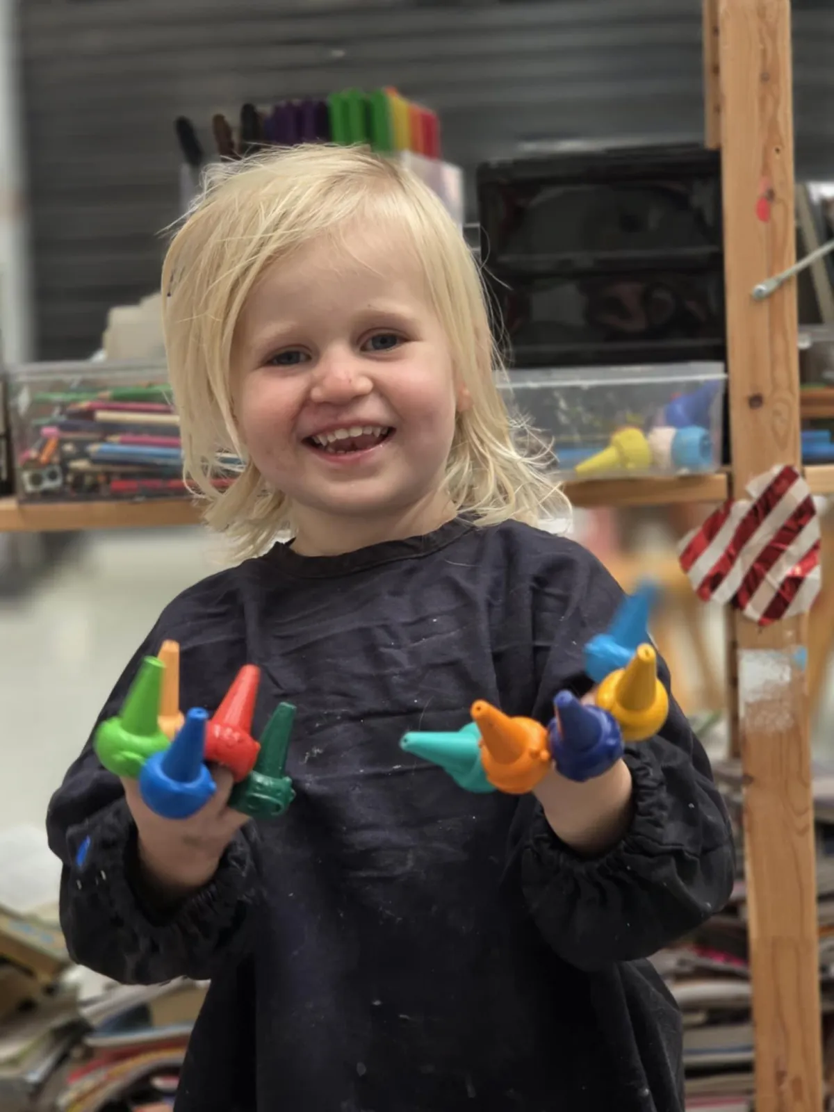 A bright lifestyle scene showing a single parent’s hands arranging colorful craft supplies on a table, natural daylight from a nearby window, candid warm mood, photorealistic editorial style, family-friendly atmosphere.