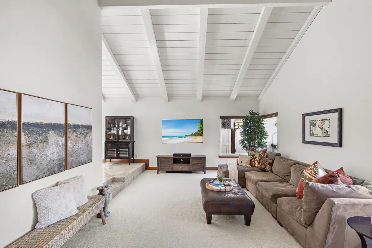 Living room at 25532 Leeward Drive featuring vaulted ceilings, natural light and a raised dining area.