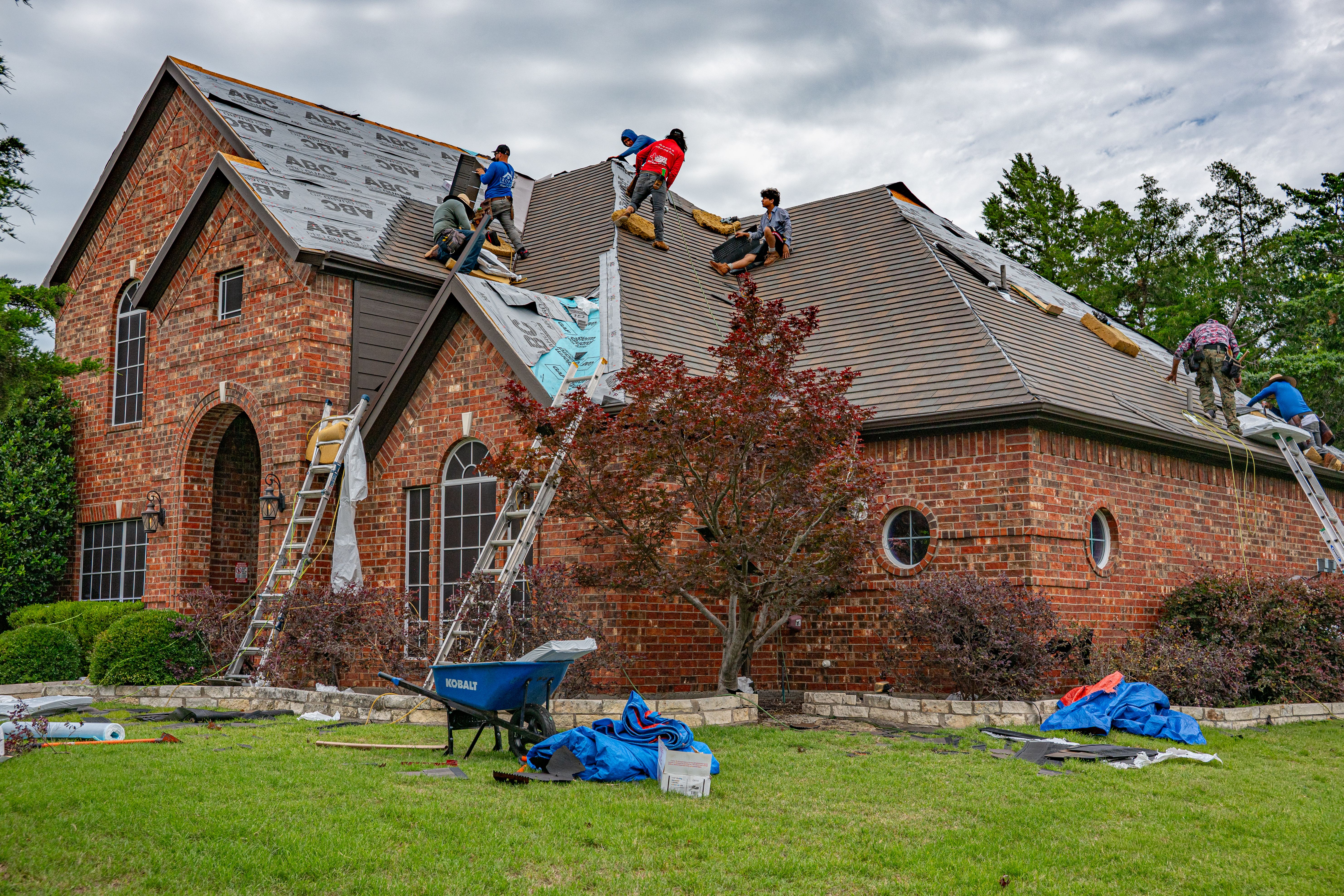 Active property under renovation with workers, ladder, and exterior scaffolding