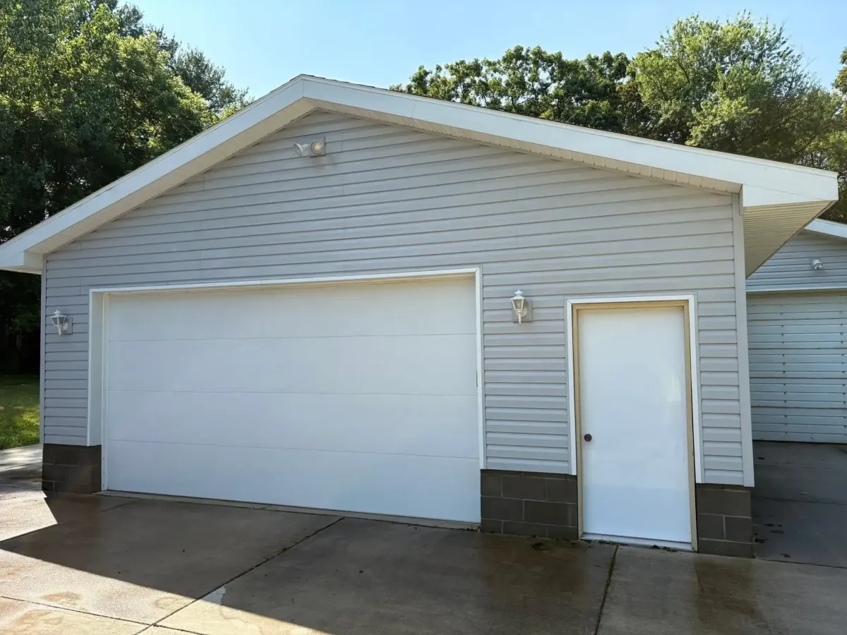 The same detached garage, now free of mildew, dirt, and streaking on the door. The garage is so clean, you can see the sunshine reflecting off the door.