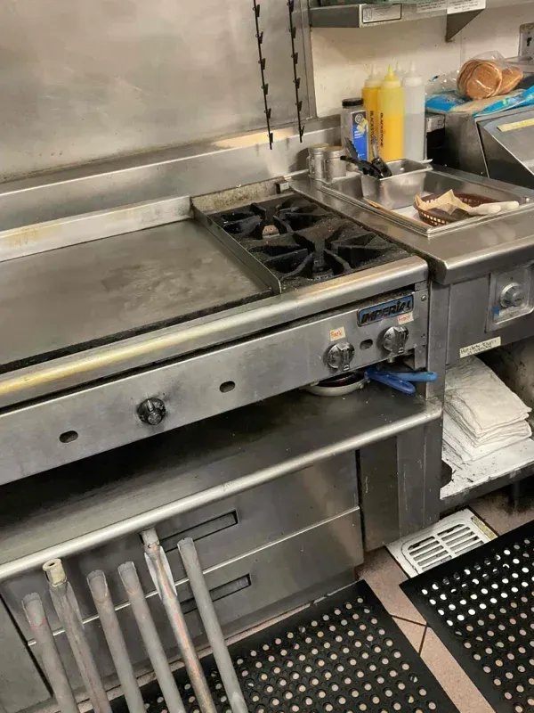 A factory-certified appliance repair technician carefully verifying voltage readings on a high-end kitchen cooking unit in Denair, CA near the Main Street corridor.
