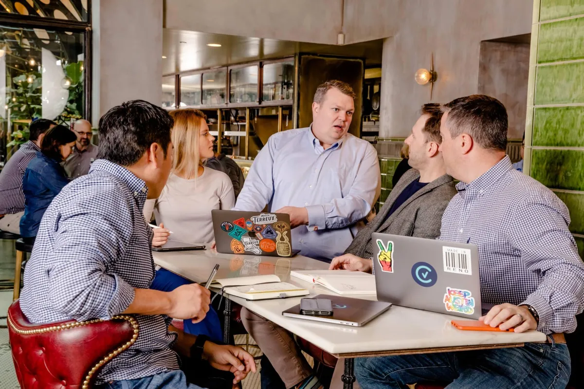 Image of Wil Kirwan Explaining Processes to people while in a coffee shop