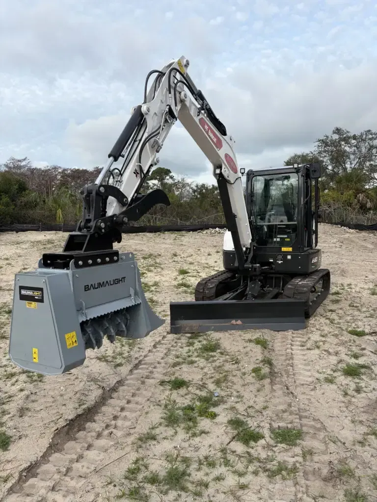 Tracked excavator clearly dense brush along a fence line
