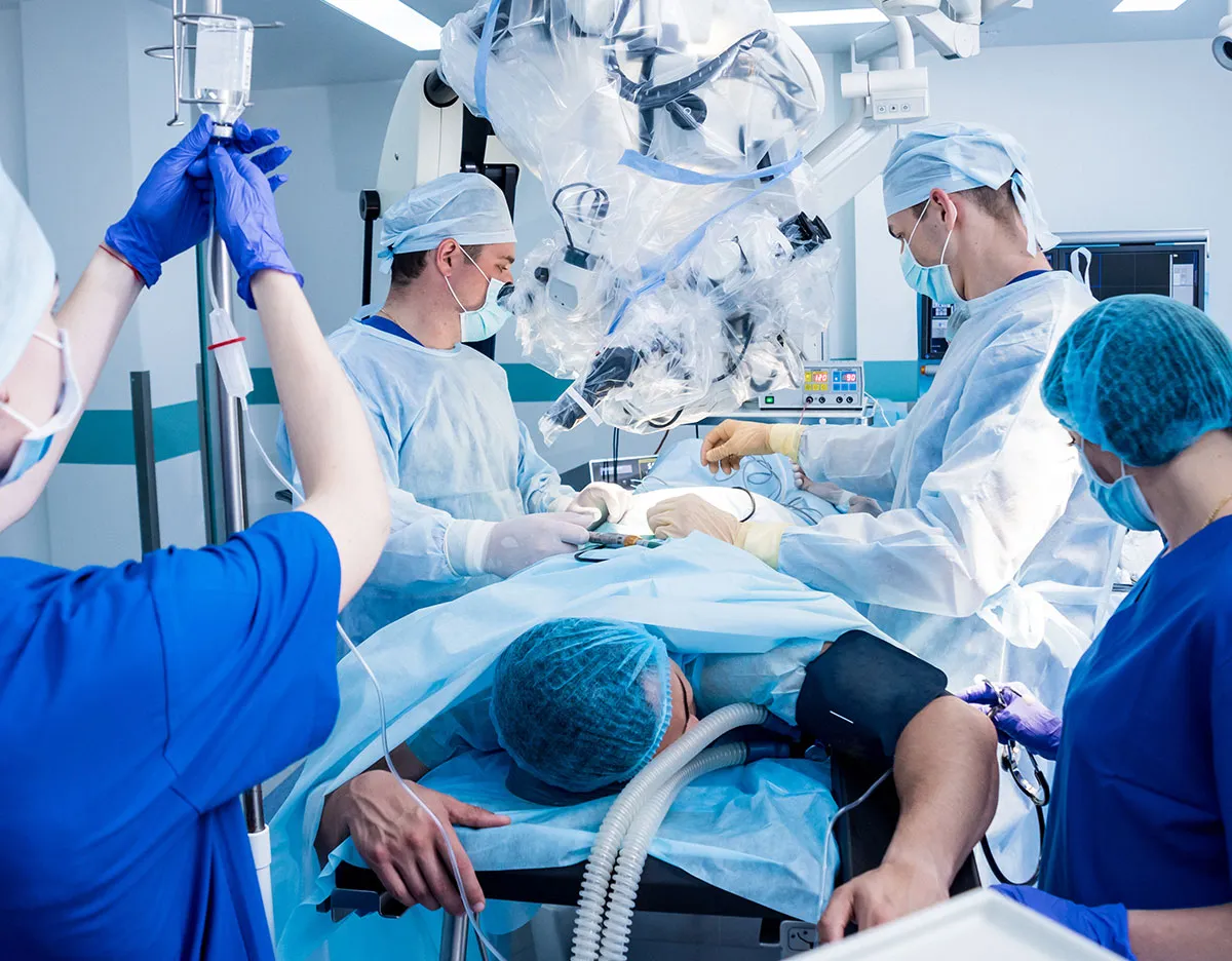 Surgical team prepares patient in prone position in operating room