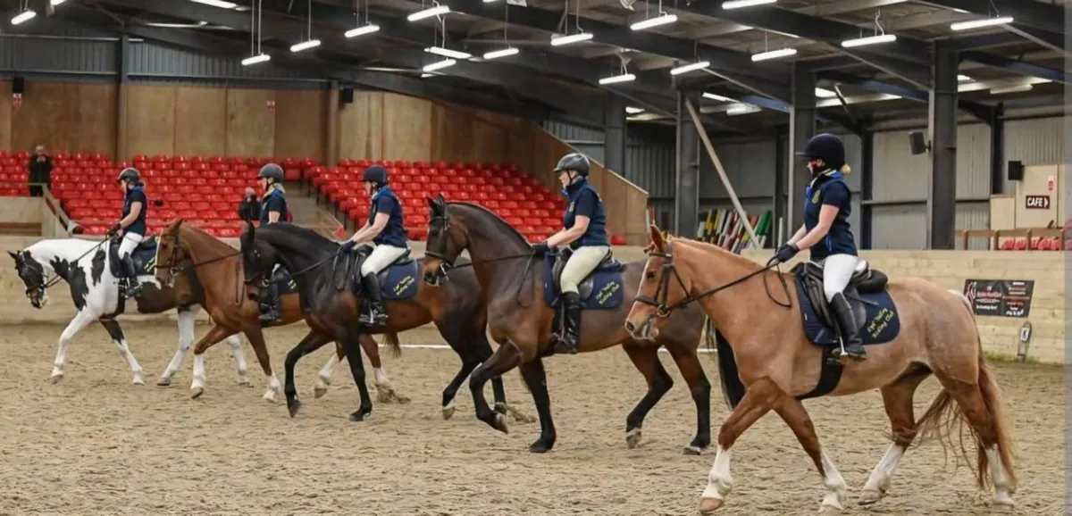 Online FormatiFive riders practising formation riding togetheron Riding Competition for teams of two or more riders