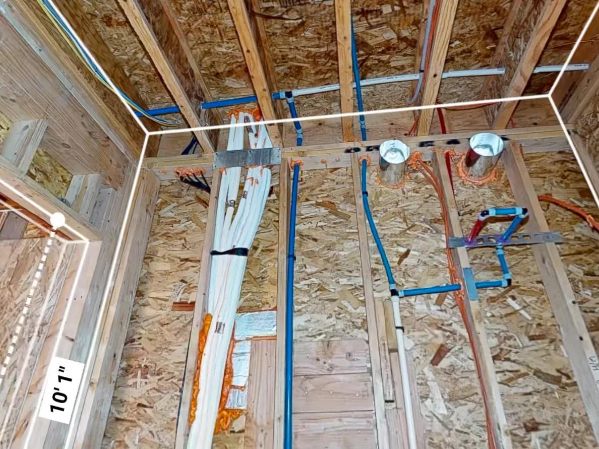 Construction rough-in framing stage brightly illuminated with heavy duty portable flood lights showing crisp wire runs and plumbing
