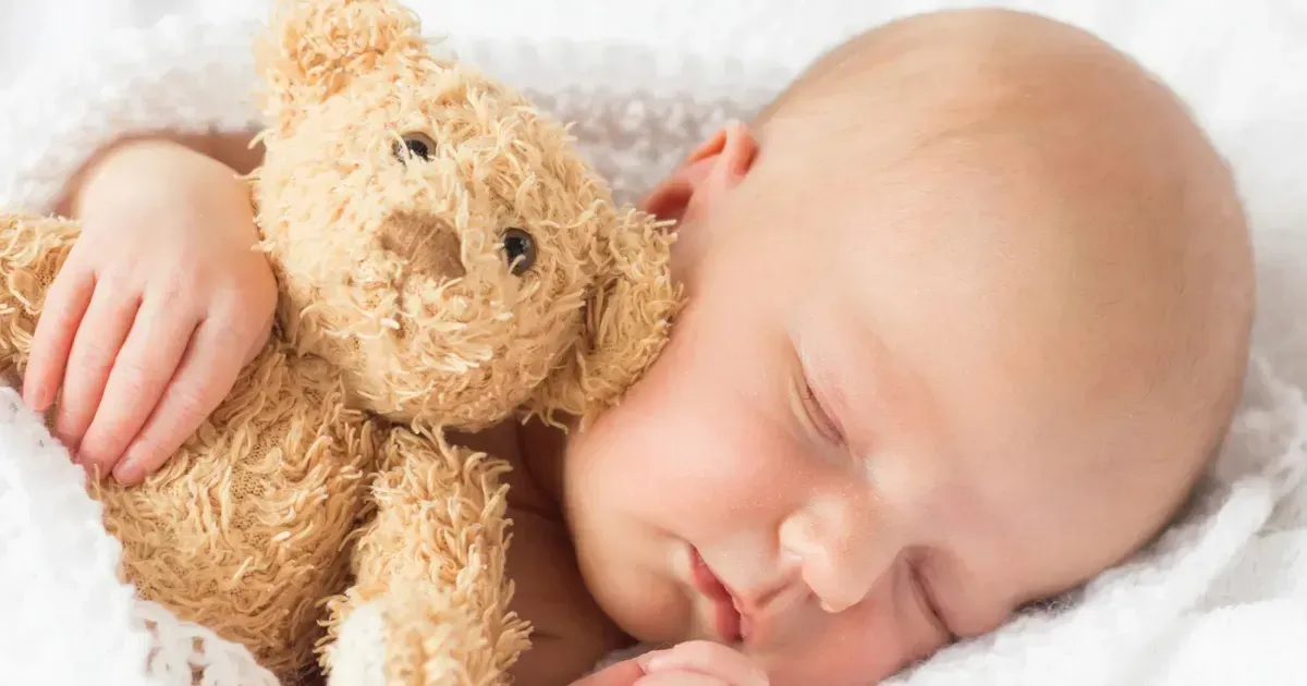 baby seeping with teddy bear