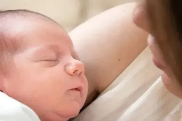 mum gazing at her sleeping newborn baby