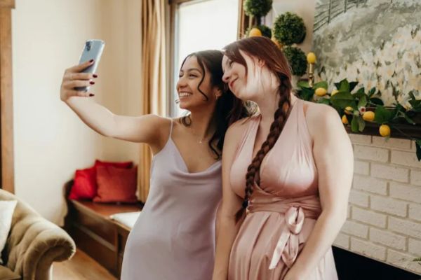two smiling women creating a meaningful moment by taking a selfie at a baby shower celebration