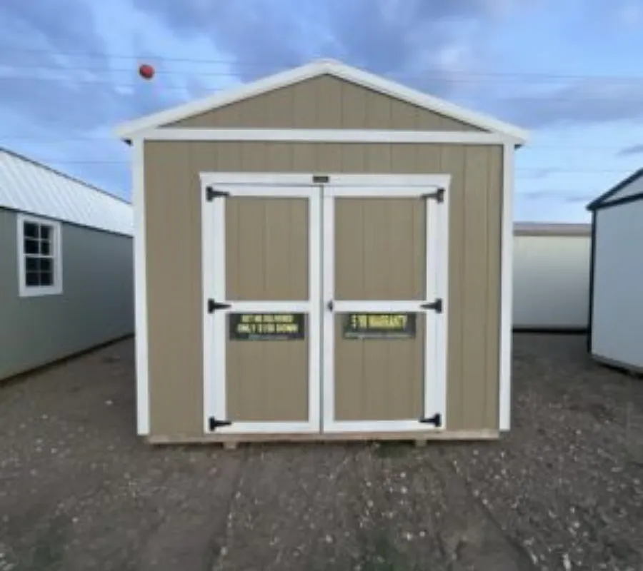Row of premium rent-to-own portable buildings, utility sheds, and cabins staged on gravel lot at Location 2