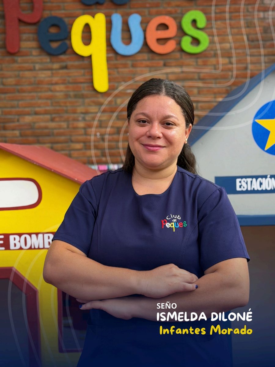 Waist-up portrait of Seño Ismelda Diloné smiling, wearing a navy polo, in front of a colorful 'Peques' sign.