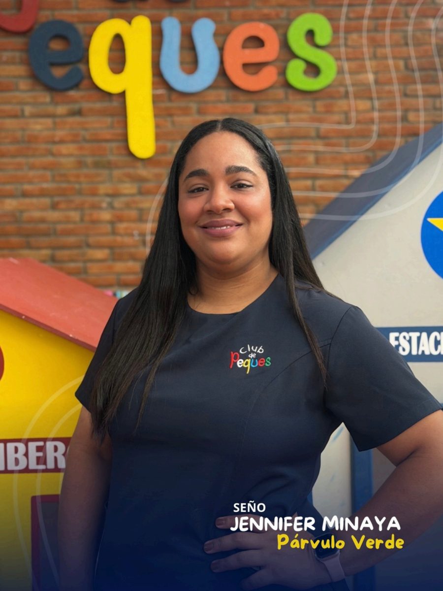 Waist-up portrait of Seño Jennifer Minaya smiling, wearing a navy polo, in front of a colorful 'Peques' sign.