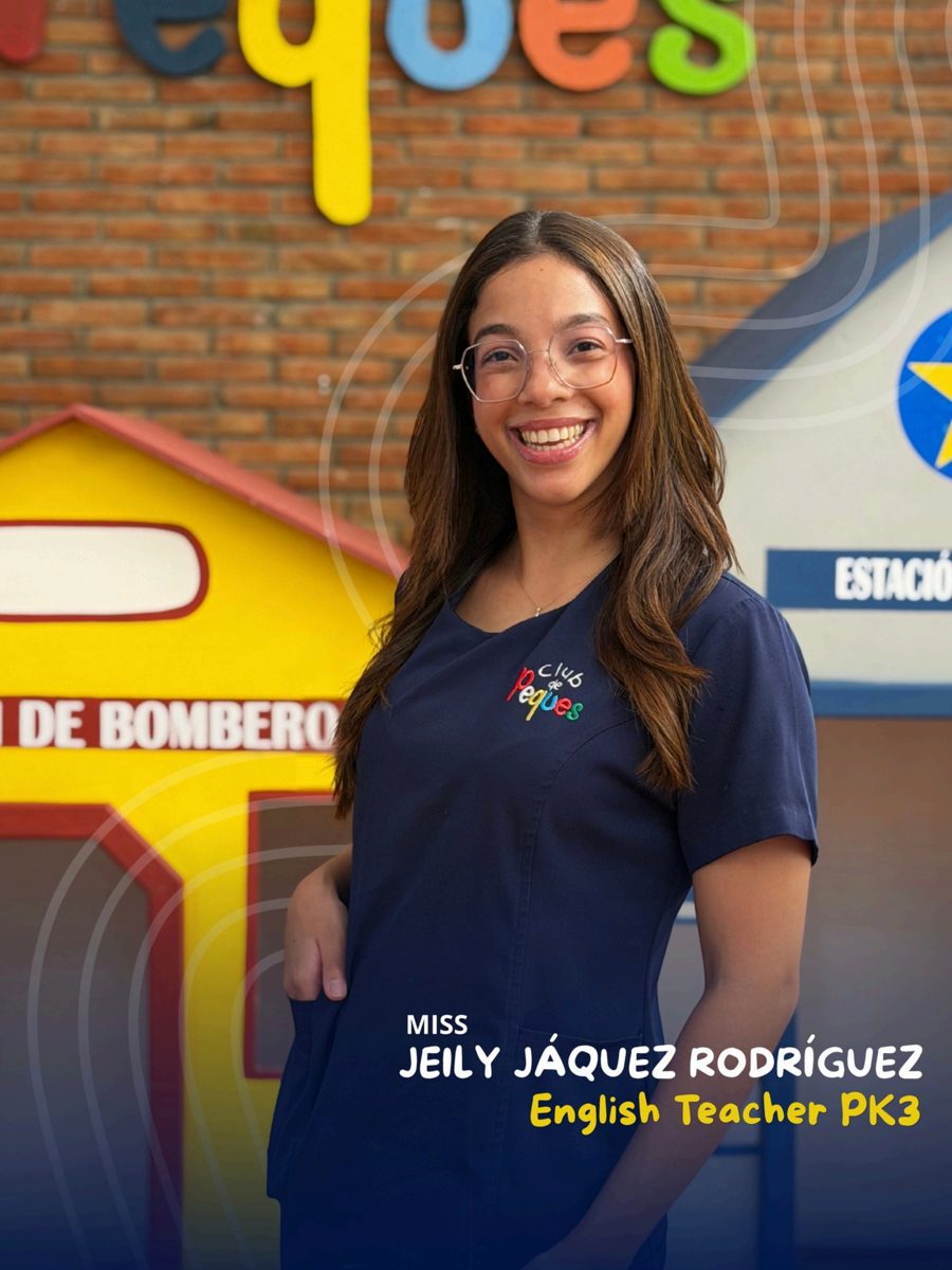Waist-up portrait of Miss Jeily Jáquez Rodríguez wearing glasses and a navy polo, in front of a colorful 'Peques' sign.