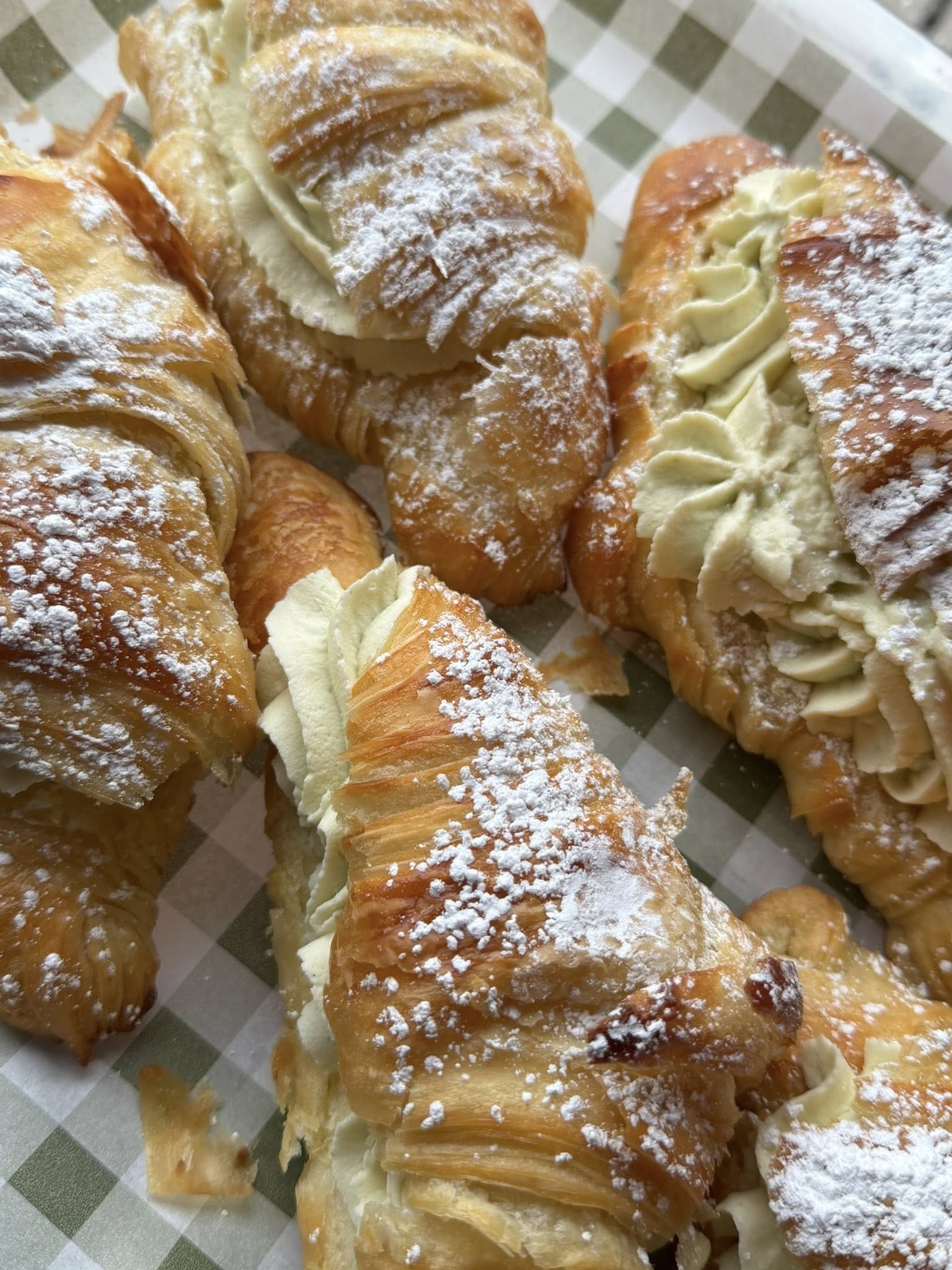 Square image of a cozy shop window with assorted pastries on display.