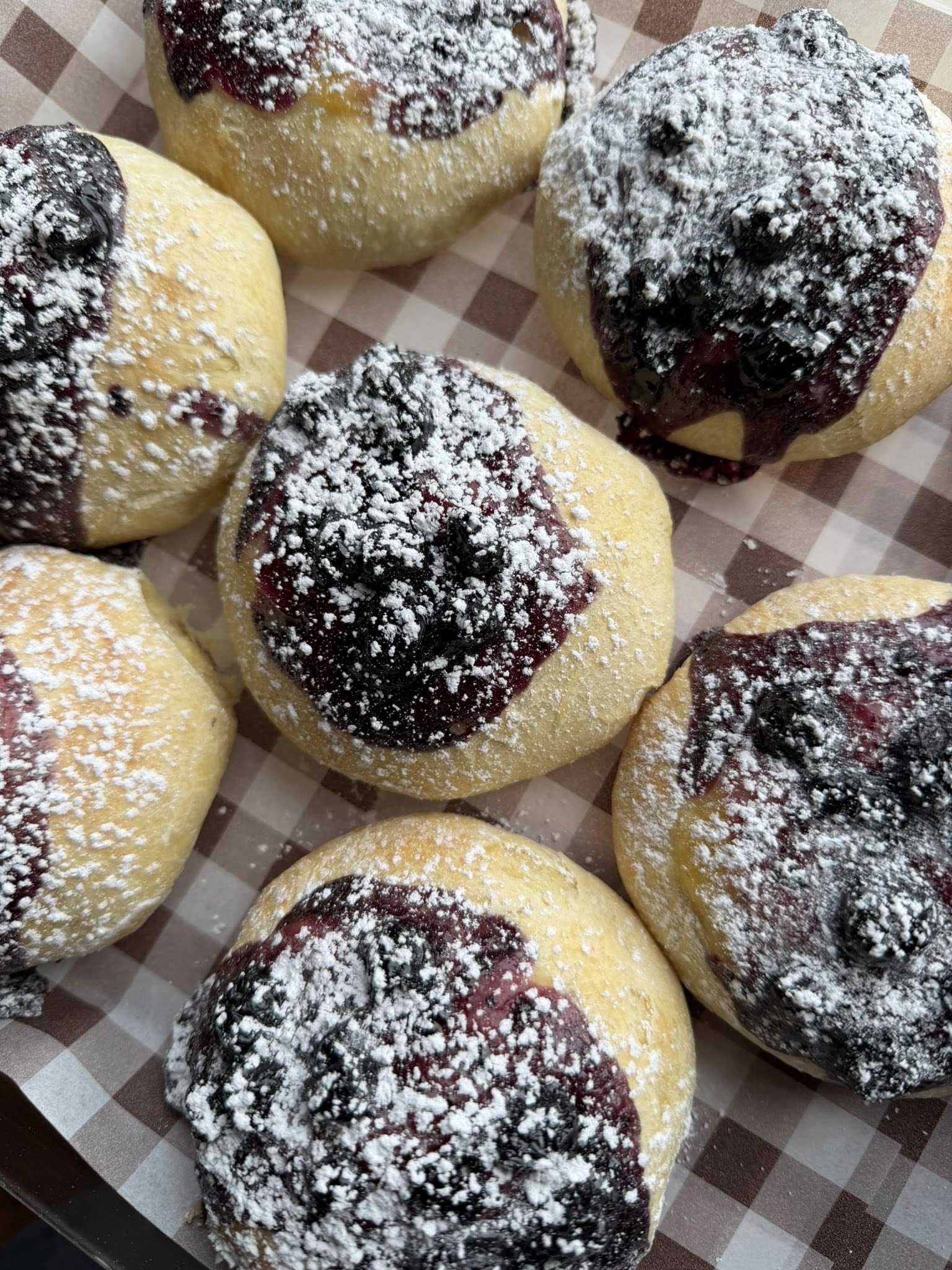 Square image of a cozy shop window with assorted pastries on display.