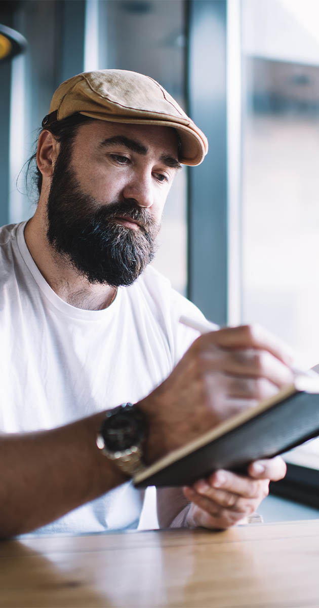 Man writing in his journal, conquering writers block