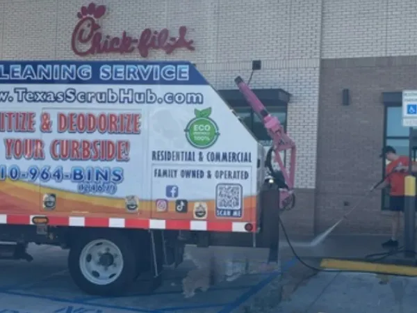 Technician pressure washing a residential driveway