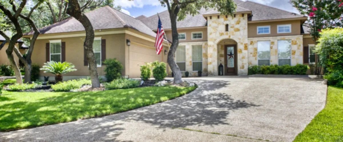 Suburban house with freshly cleaned driveway and landscaped yard.