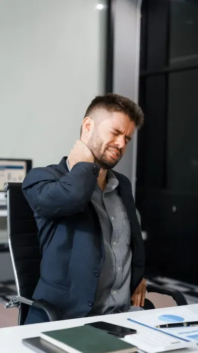 Man at desk experiencing neck pain