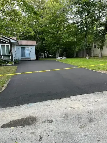 Freshly paved residential driveway in Newport, Maine by Maine Paving and Sealcoating